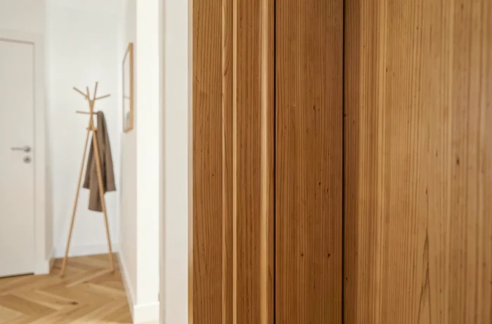 Porte postformée en chêne clair avec bords arrondis dans un couloir scandinave moderne